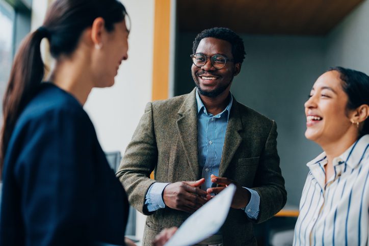 Business professionals engaging in a lively discussion in an office.